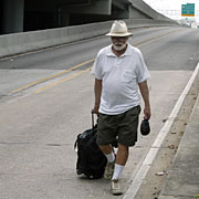 Dan Fuller, of New Orleans, gives up trying to hitch a ride on Interstate 10 as he heads to the Superdome for shelter.